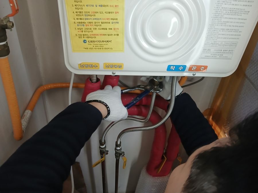보일러 아래 언 수도 배관을 확인하는 언수도녹임작업